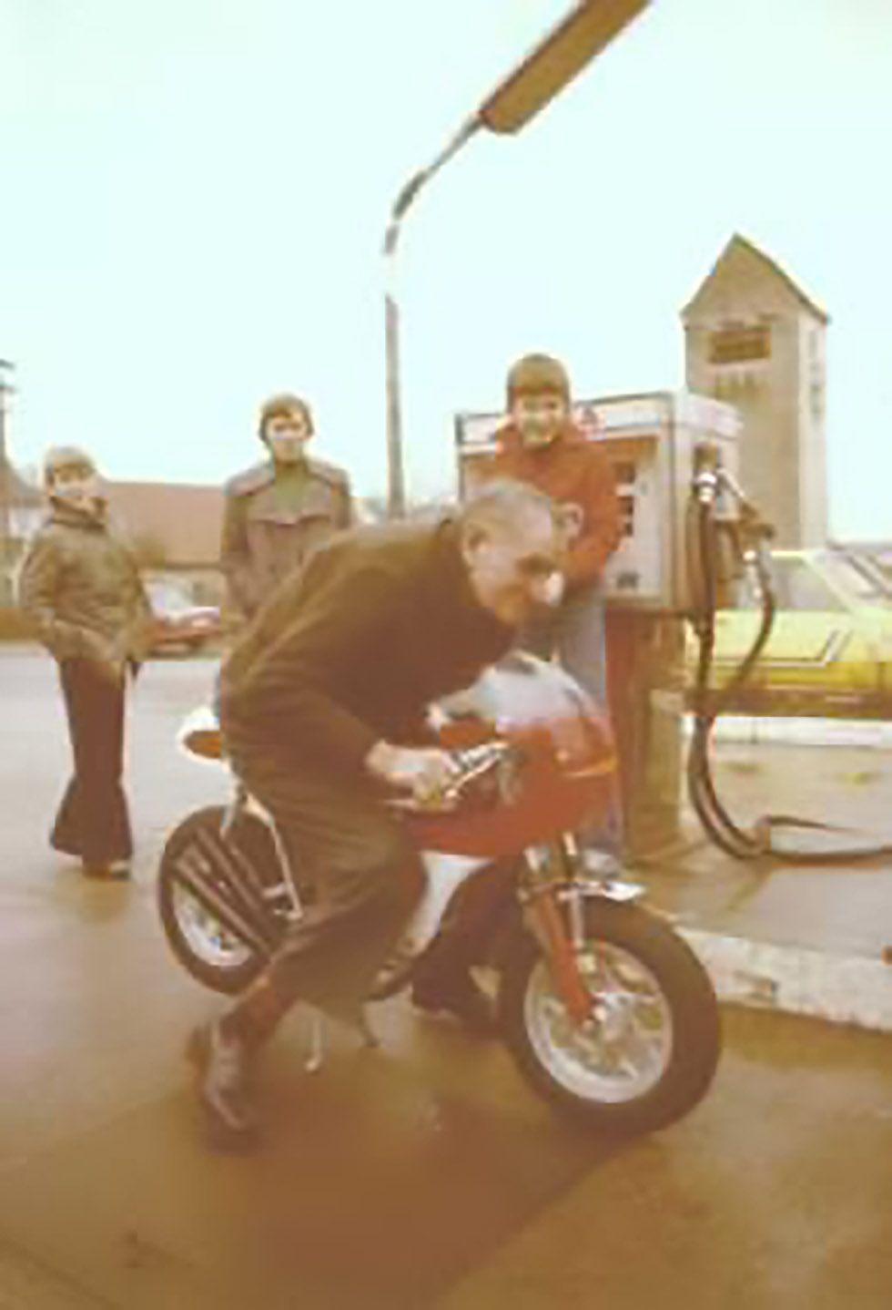 Großvater Johann probiert das kleine Motorrad aus